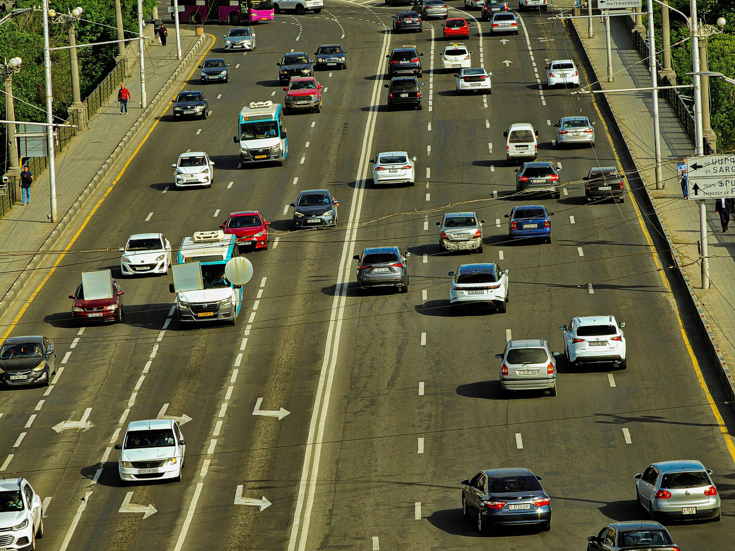 A high-angle view of a busy urban highway with several cars, showcasing city transportation.